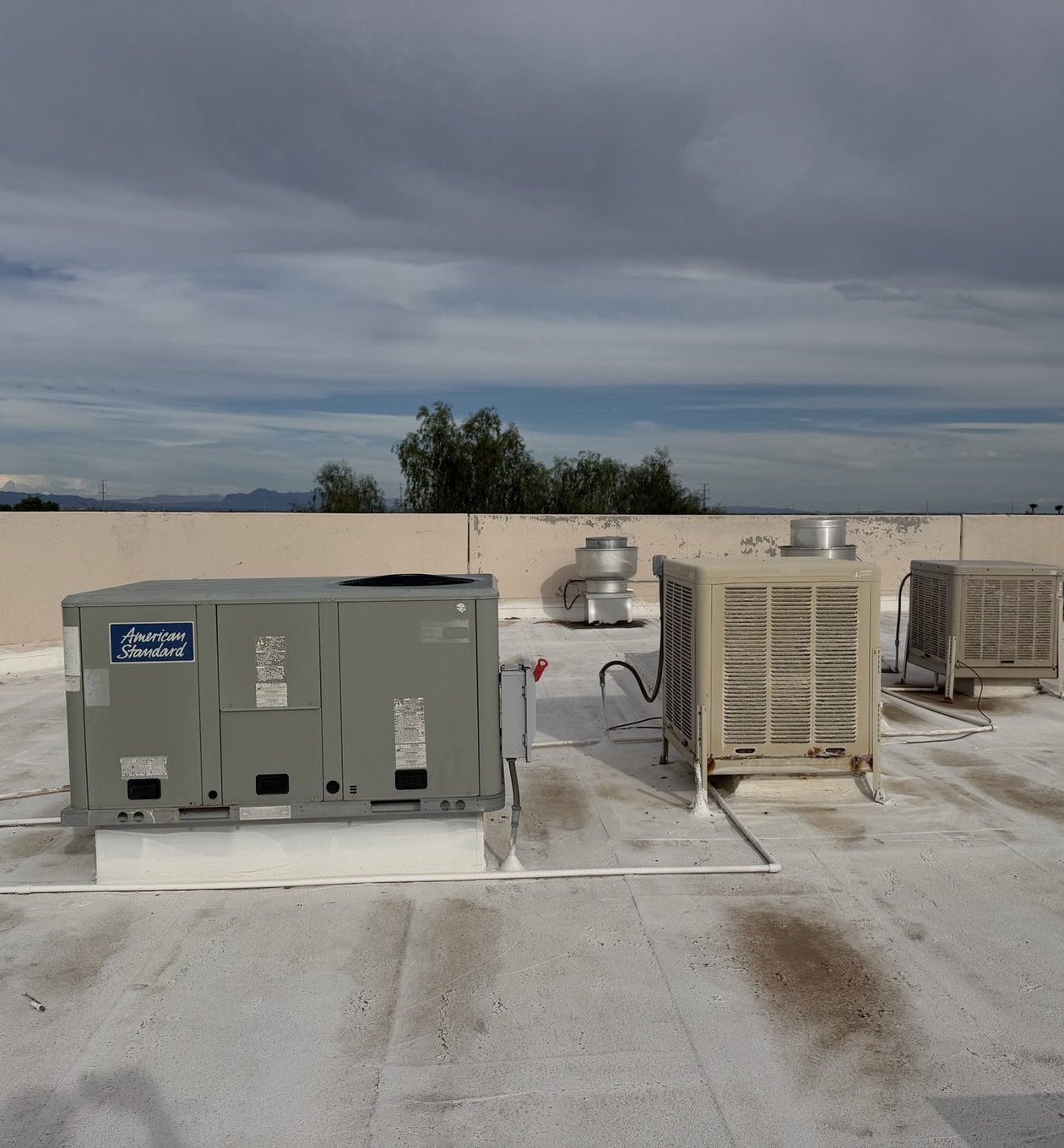 Packaged rooftop units and swamp coolers on a multi-tenant commercial roof