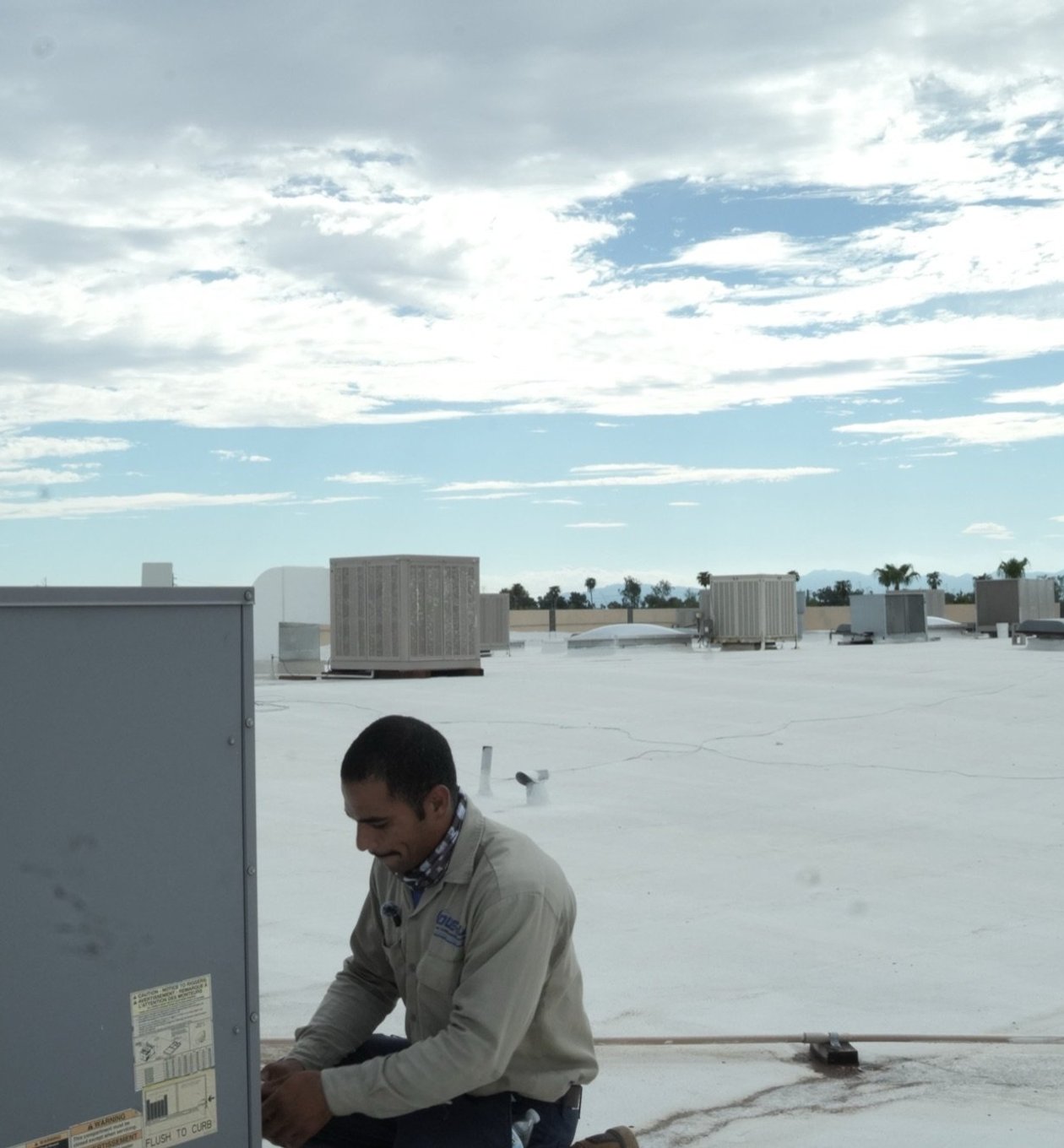 Due-All technician performing scheduled maintenance on a rooftop unit