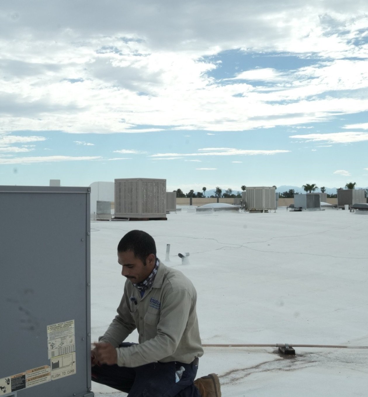 Due-All technician inspecting a commercial rooftop unit