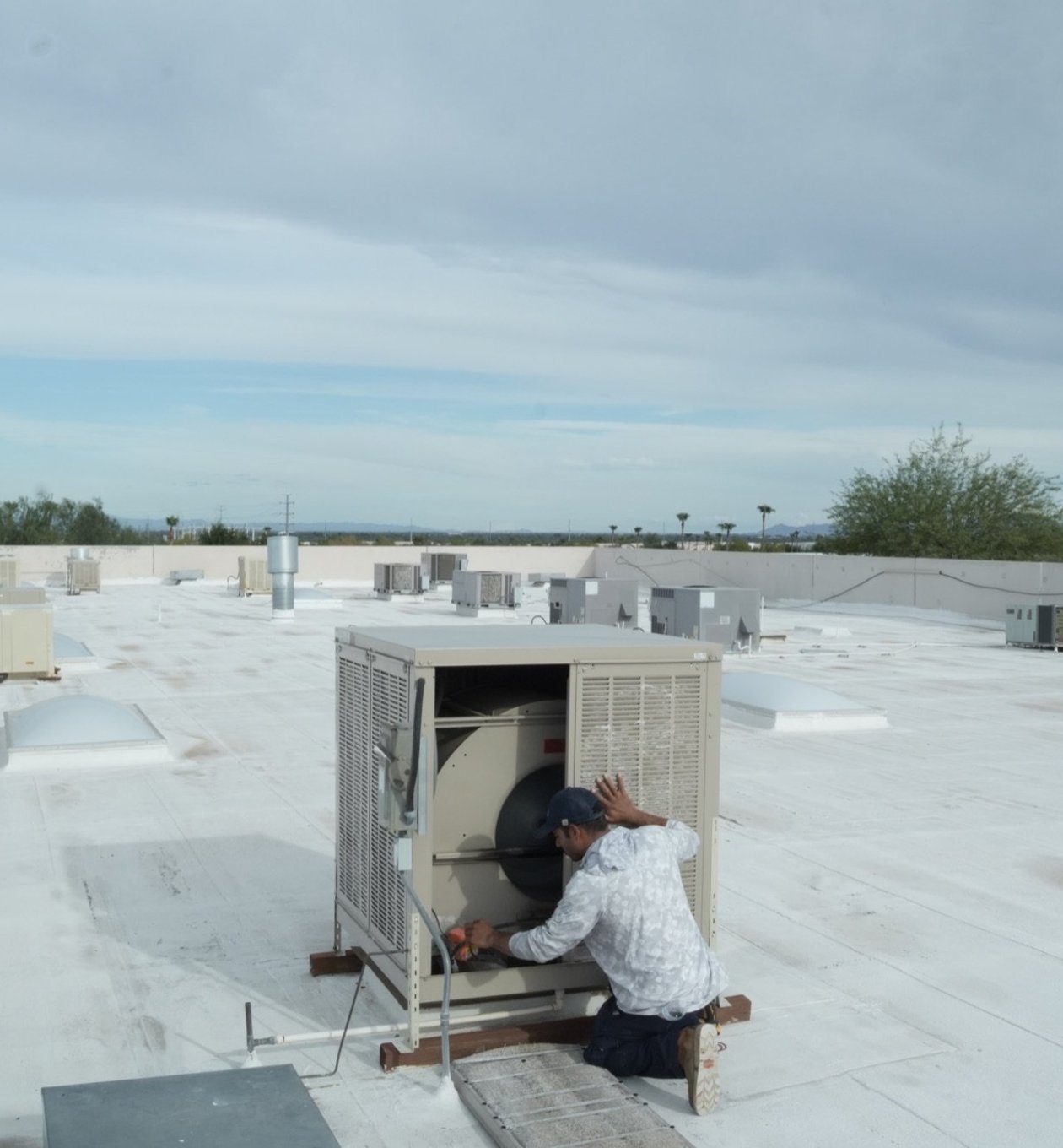 Due-All technician servicing a commercial swamp cooler with the panel off